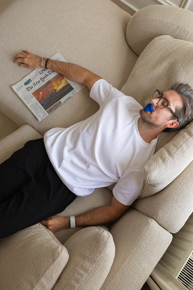 Man using Bedrock mouth tape to boost deep sleep, support natural breathing, and boost energy.